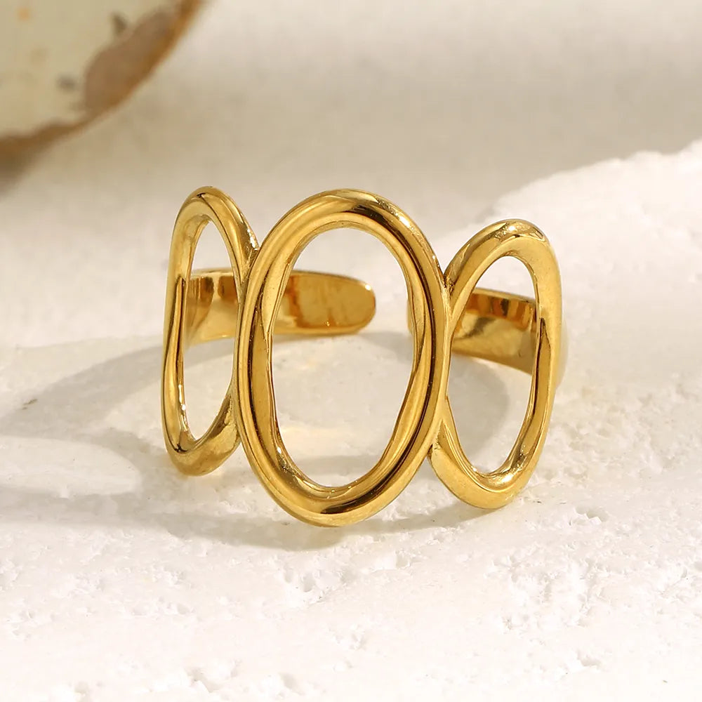 Anillo corona dorado con tres óvalos pulidos sobre fondo claro