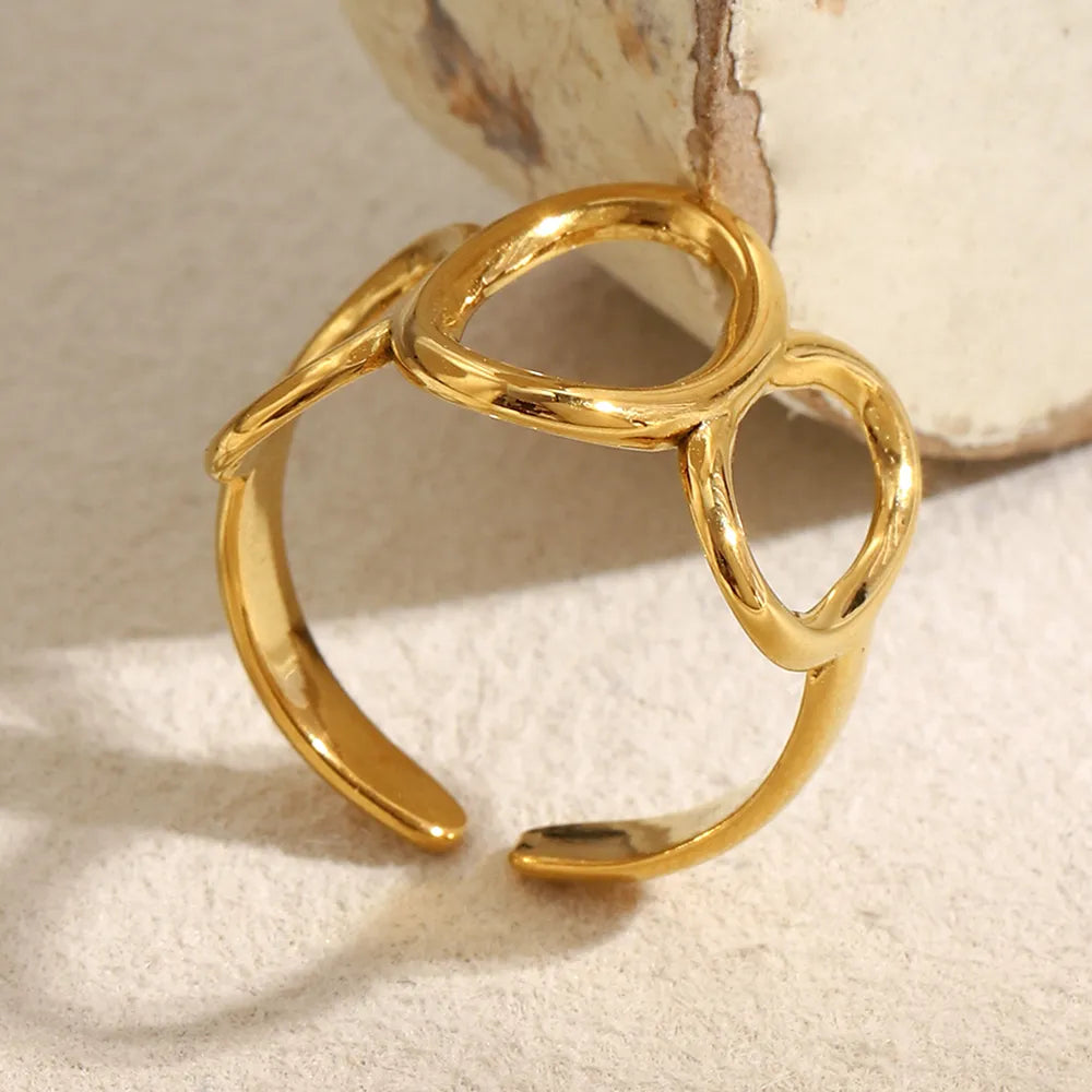 Anillo corona dorado abierto visto en perspectiva, destacando su estructura ajustable