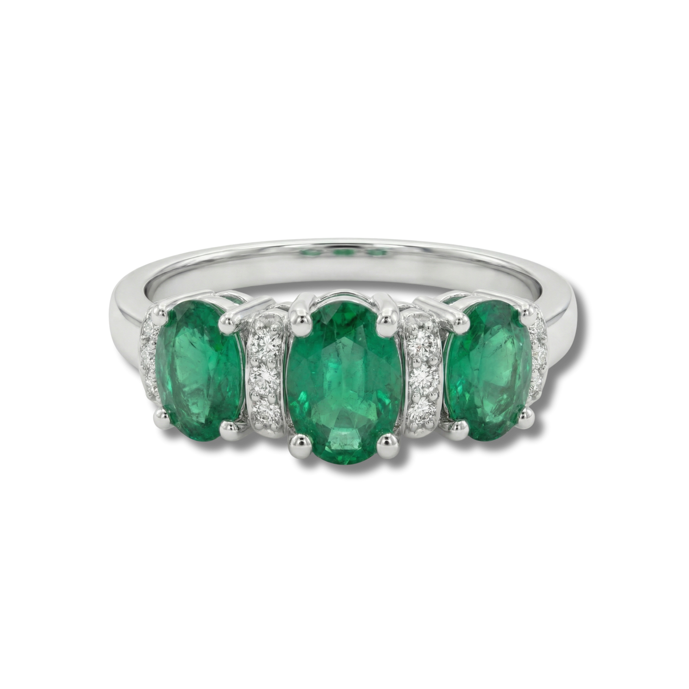 Anillo con esmeraldas y detalles de diamantes en plata, diseño de tres piedras