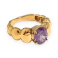 Anillo solitario de piedra morada en acero dorado