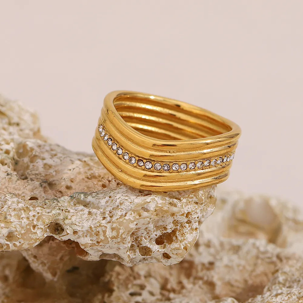 Anillo multicapa de cristales blancos en acero dorado