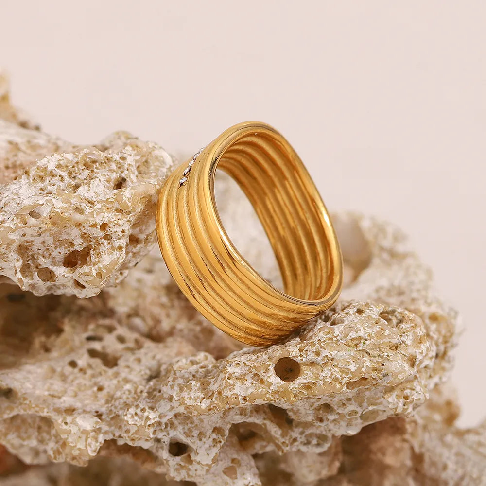 Anillo multicapa de cristales blancos en acero dorado