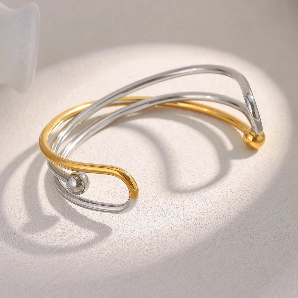Pulsera brazalete entrecruzado bicolor en acero dorado