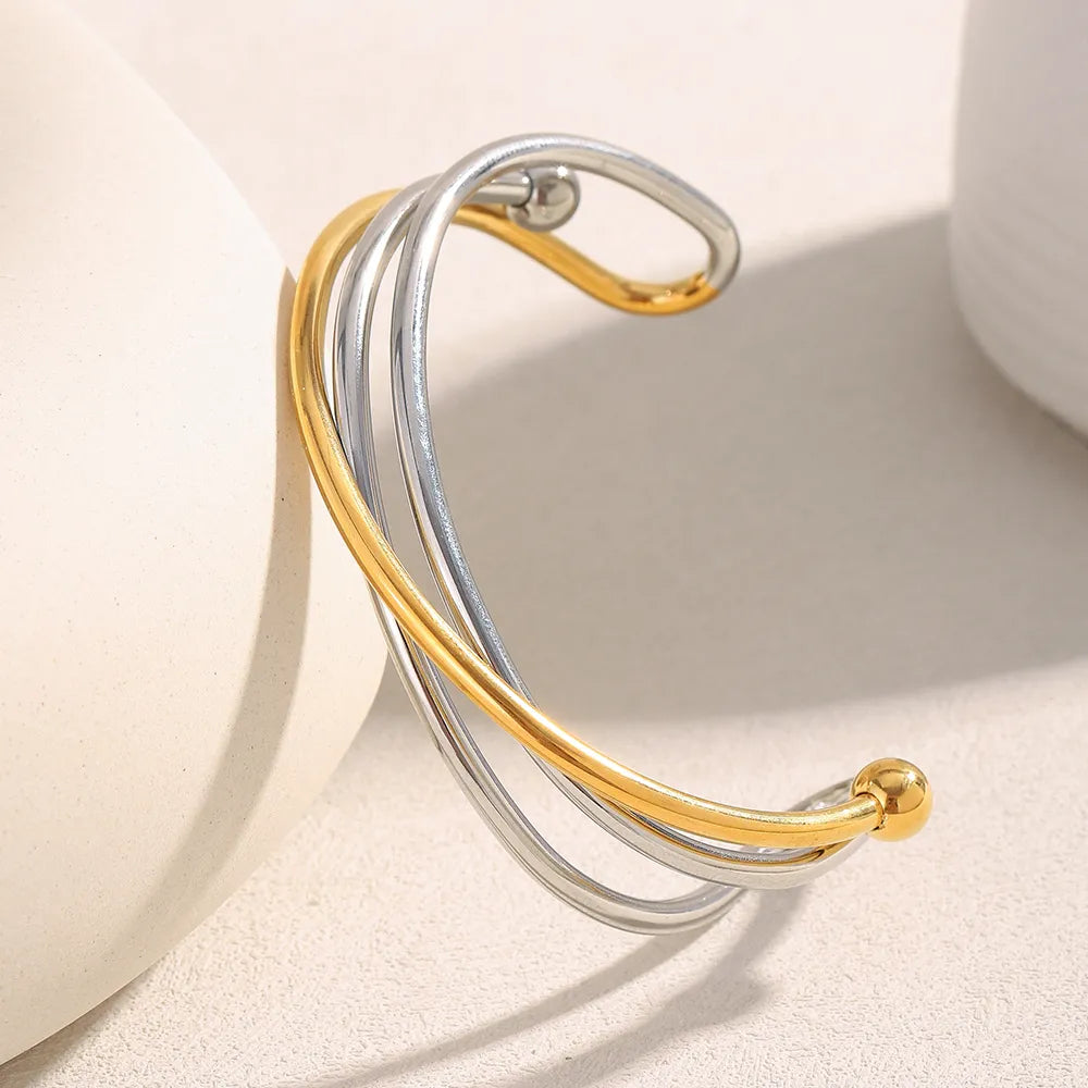 Pulsera brazalete entrecruzado bicolor en acero dorado