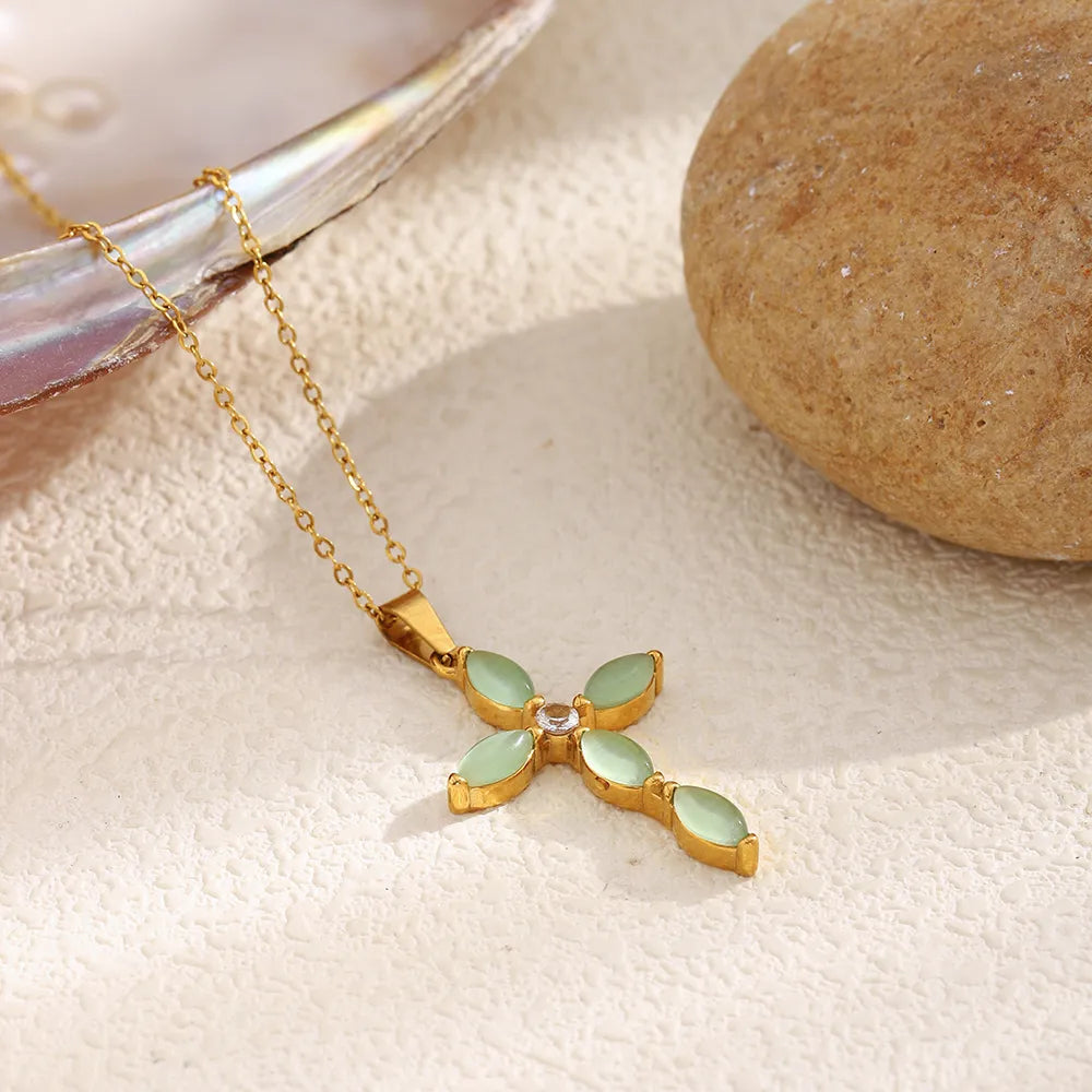 Collar con cruz de piedras verdes en acero dorado