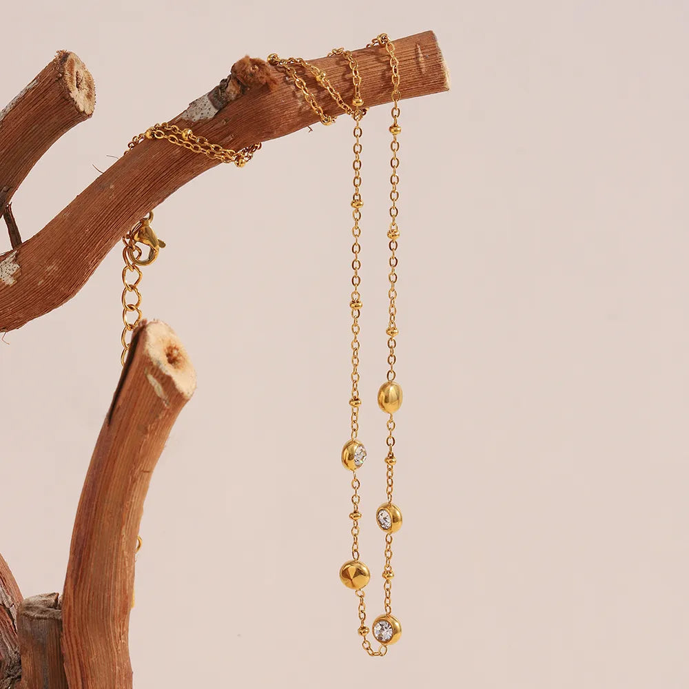 Collar con engaste en bisel de circonitas en acero dorado